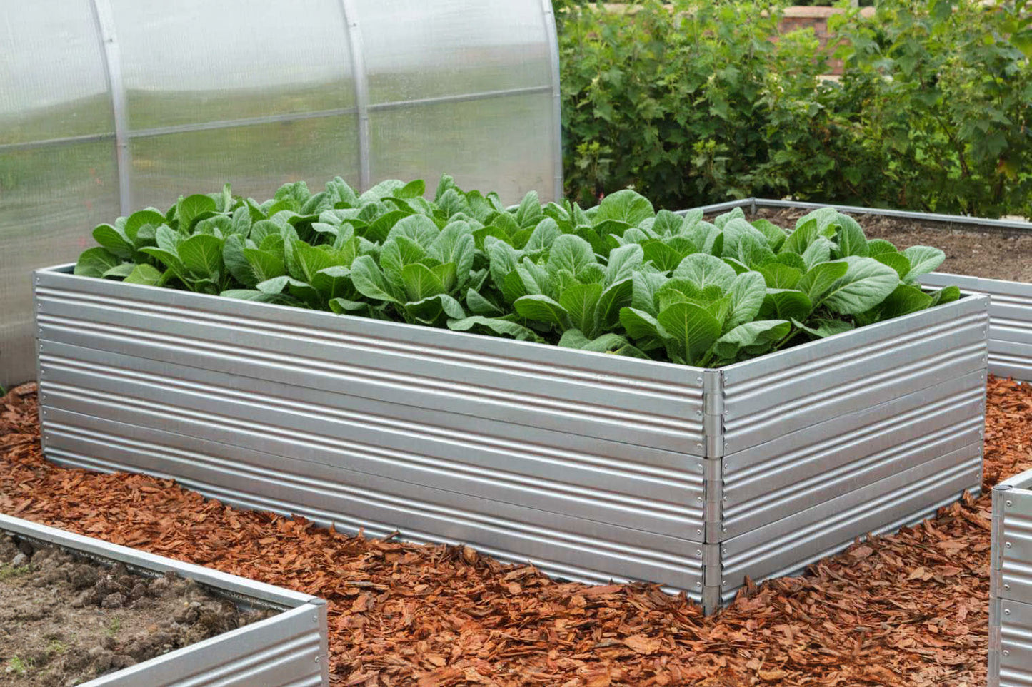 Metal raised Planta Garden Bed - 3 Tiers with green plants in a garden setting